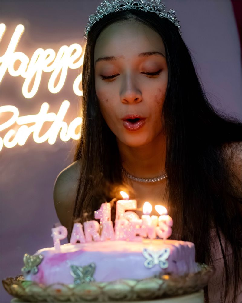 Jovem soprando as velas do bolo de aniversário